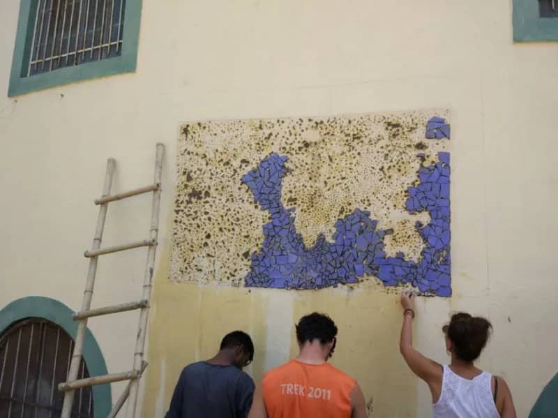 Freiwillige verzieren eine Wand, Goa/Indien