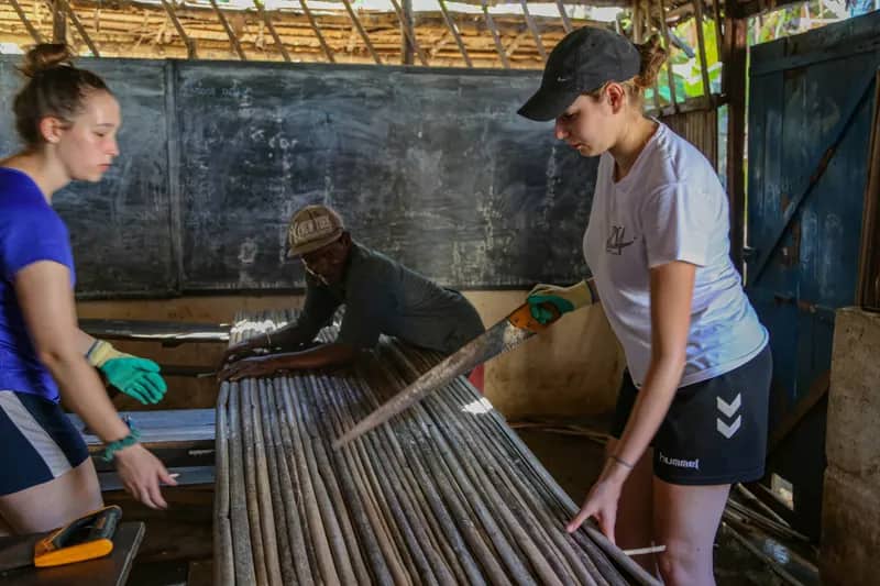 Freiwillige sägen im Bau- und Renovierungsprojekt Nosy Be auf Madagaskar